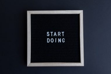 Black letter board with the motivational phrase 'Start Doing' in white text on a gray background.